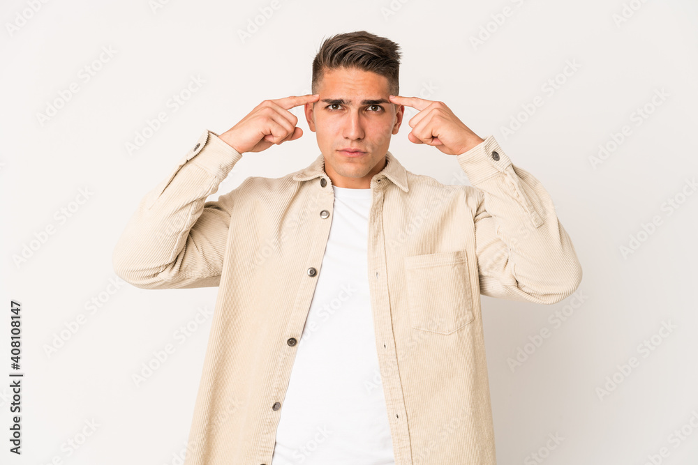 Young caucasian handsome man isolated focused on a task, keeping forefingers pointing head. Young caucasian handsome man isolated focused on a task, keeping forefingers pointing head.