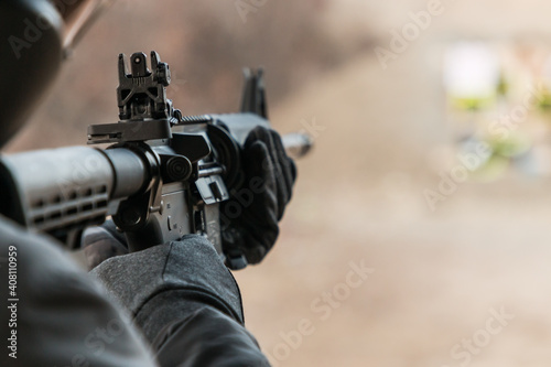 Person shooting a semi-automatic AR-15 assault weapon rifle at an outdoor gun range