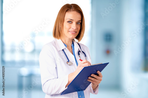 Portrait of middle aged female doctor standing in doctor's office