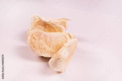 side view of a half of a tangerine divided into slices in the form of a snake