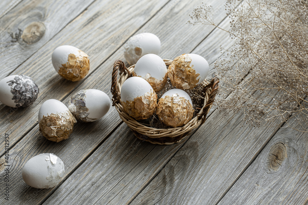 Obraz premium Easter composition with decorated eggs in a basket on a wooden surface.