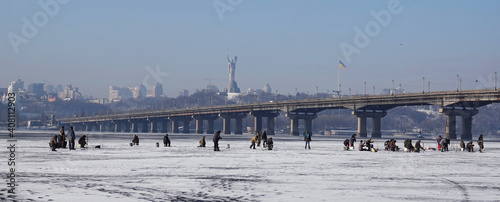 Fototapeta Naklejka Na Ścianę i Meble -  Fishermen on ice catch fish