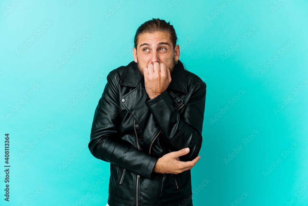 Young man with long hair look biting fingernails, nervous and very anxious. Young man with long hair look biting fingernails, nervous and very anxious.
