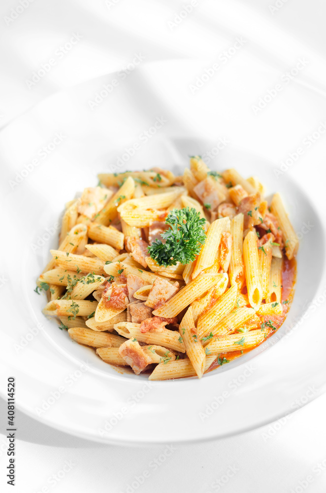 penne amatriciana tomato and ham sauce pasta on white table penne amatriciana tomato and ham sauce pasta on white table