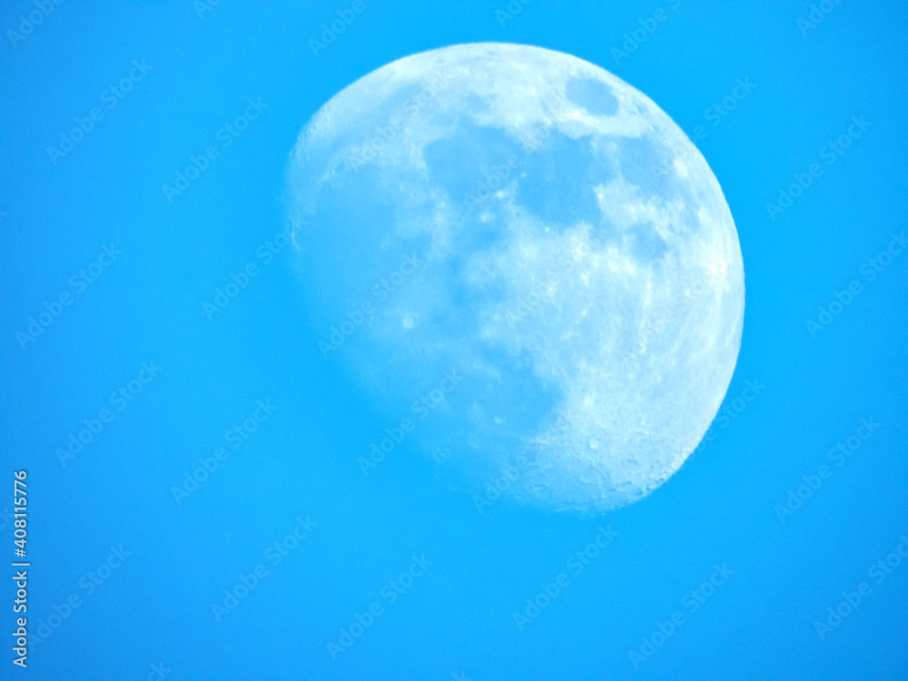 Naklejka premium Lune en plein jour avec un ciel bleu