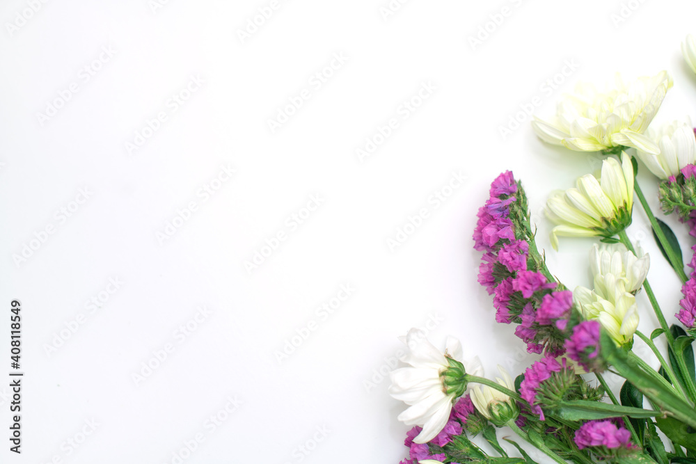 Pink statice and white chrysanthemum flowers on a white background. Top view. Copy space. Space for the text. The concept of the holiday.