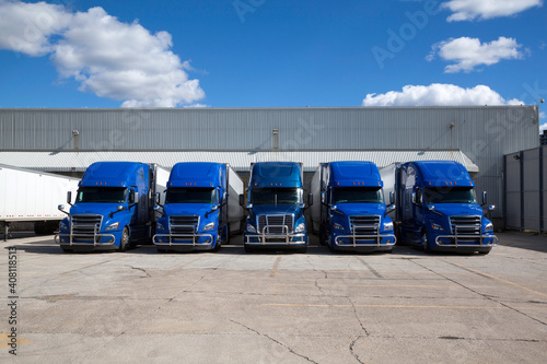 Blue Transport Trucks Lined Up in the Yard of a Warehouse photo