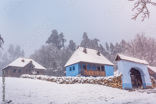 Traditional Romanian village in Transylvania with old house straw roofing covered with snow in a cold day