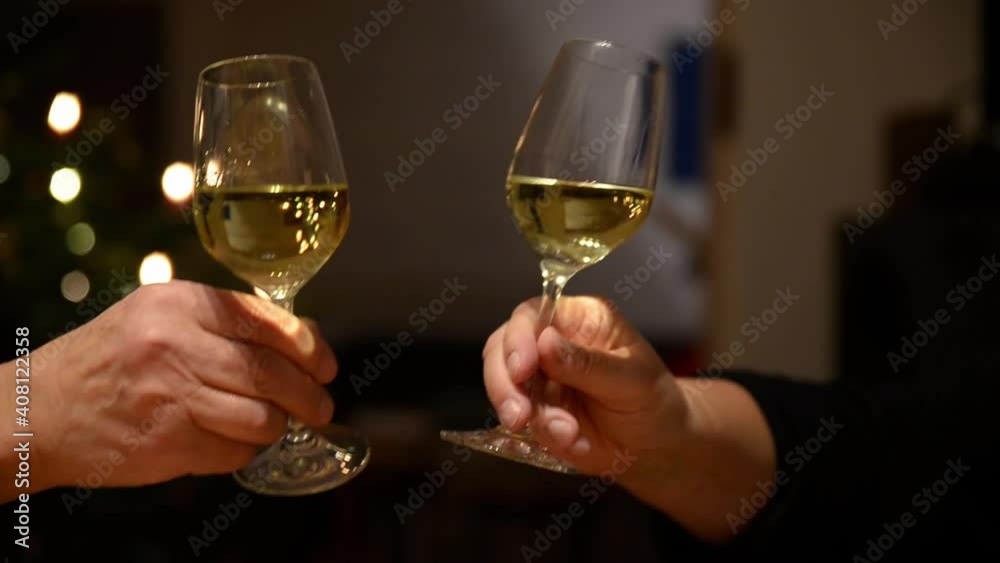 Close up of two persons clinking glasses. Close up of two persons clinking wine glasses. Close up of two persons clinking glasses. Close up of two persons clinking wine glasses.