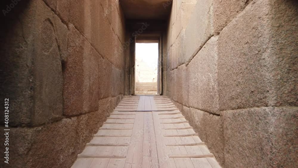 Discovery of the pyramids through a long corridor and a door, long stone path that leads to the pyramid of khephren, a man walks towards the pyramids Discovery of the pyramids through a long corridor and a door, long stone path that leads to the pyramid of khephren, a man walks towards the pyramids