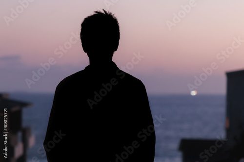 Silhouette of man at ocean sunset at Manhattan Beach, California