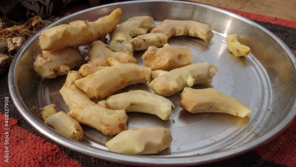 Fresh peeled ginger roots in a steel plate. Indian Zingiber officinale (adarak) used as a spice and a folk medicine Fresh peeled ginger roots in a steel plate. Indian Zingiber officinale (adarak) used as a spice and a folk medicine