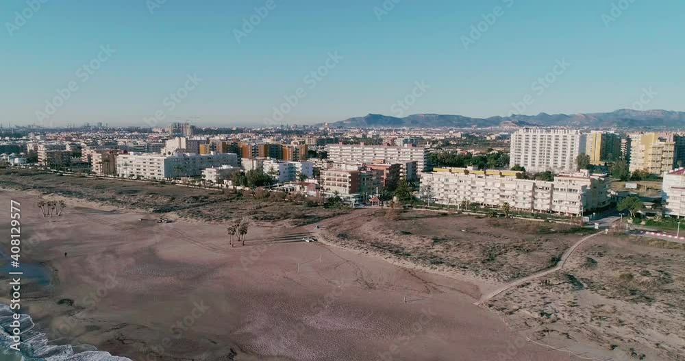 Aerial side view of a holiday seafront town with an empty beach Aerial side view of a holiday seafront town with an empty beach