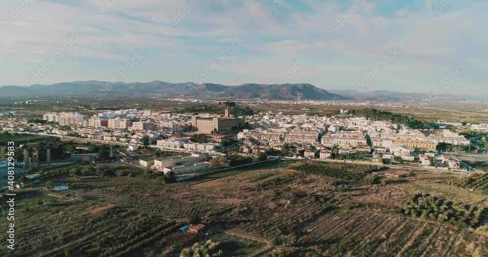 Aerial side view of a small town surrounded by fields with a monastery in the center Aerial side view of a small town surrounded by fields with a monastery in the center