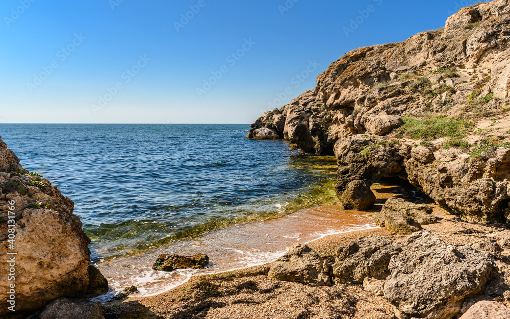 Small bay and a wild beach with rocky shores. The landscape of the untouched seashore.