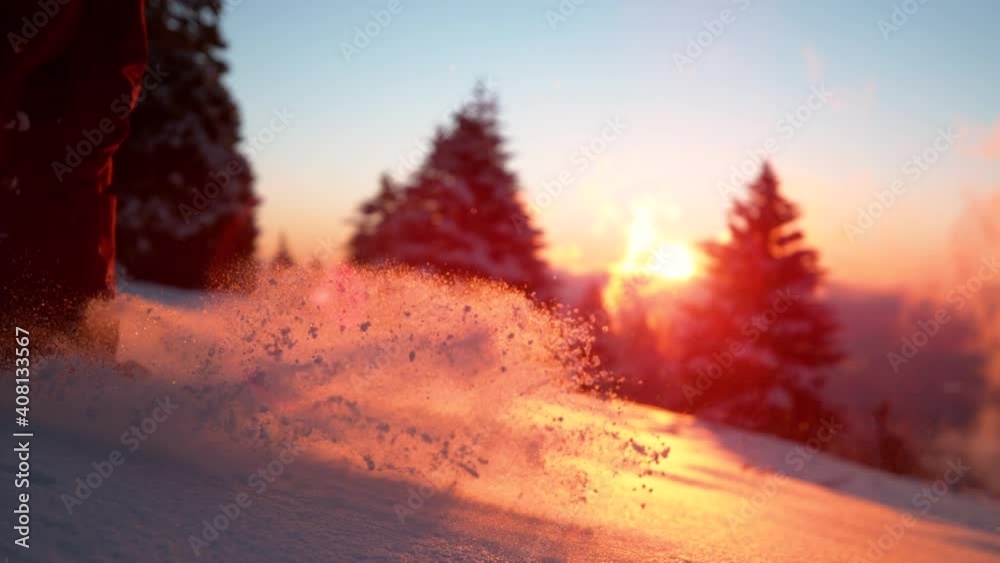 SLOW MOTION, LOW ANGLE, CLOSE UP, LENS FLARE, DOF: Tiny snowflakes glisten in the beautiful golden winter evening sunlight as unrecognizable woman walks in powder snow. Female tourist treading snow. SLOW MOTION, LOW ANGLE, CLOSE UP, LENS FLARE, DOF: Tiny snowflakes glisten in the beautiful golden winter evening sunlight as unrecognizable woman walks in powder snow. Female tourist treading snow.