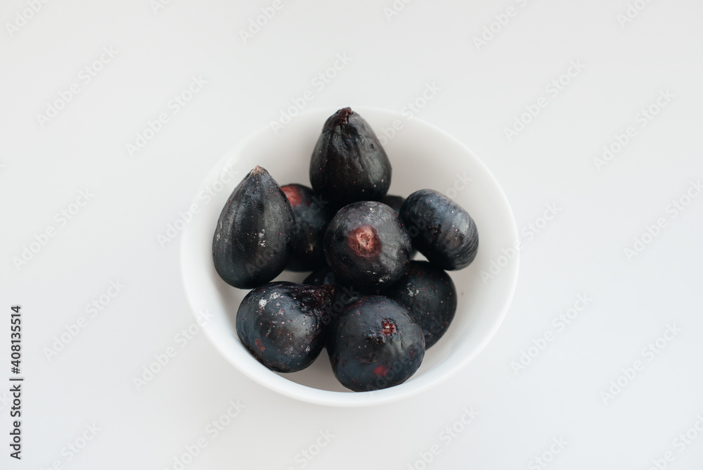 Ripe and sweet figs cut and arranged in a plate on a white background with free space. Fruits and vegetarianism Ripe and sweet figs cut and arranged in a plate on a white background with free space. Fruits and vegetarianism