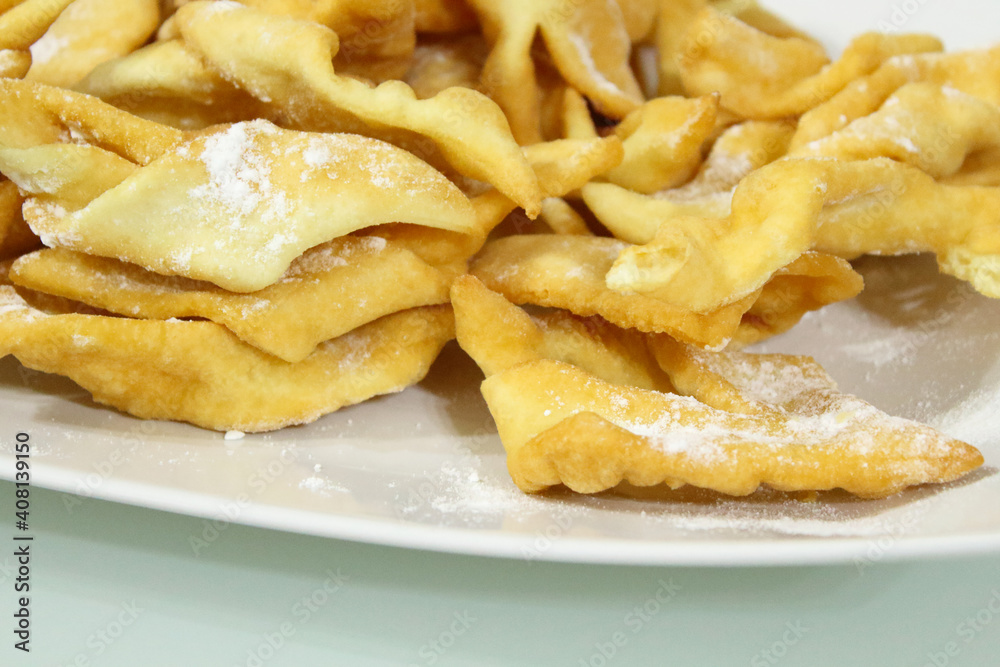 Fresh biscuits brushwood on a white plate on the table. Close-up. Background. Fresh biscuits brushwood on a white plate on the table. Close-up. Background.