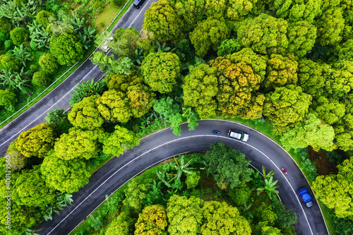 Aerial view on road in the forest. Highway throu the forest. View from a drone. Natural landscape in summer time from air. Travel and vacation image
