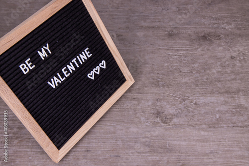 A sign that says Be My Valentines on a wooden background