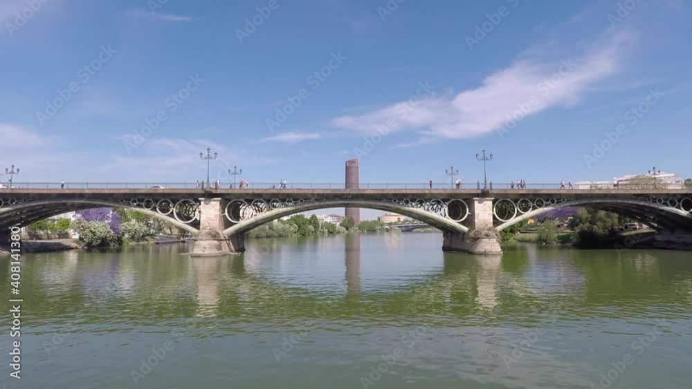 Shot of Seville Tower and Triana Bridge from a boat on the Guadalquivir river Shot of Seville Tower and Triana Bridge from a boat on the Guadalquivir river