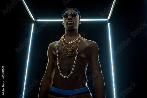 Serious rapper in gold chains, bottom view photo