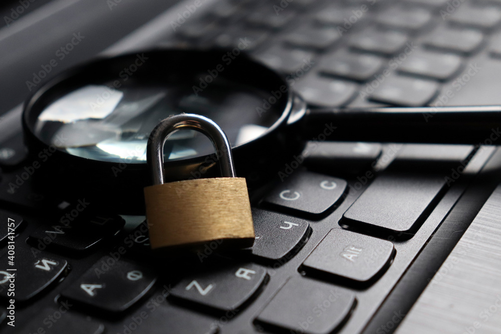 Lock with magnifying glass on the computer keyboard. The concept of security of search engines. Search and protect your computer from viruses and cyber attacks. Lock with magnifying glass on the computer keyboard. The concept of security of search engines. Search and protect your computer from viruses and cyber attacks.