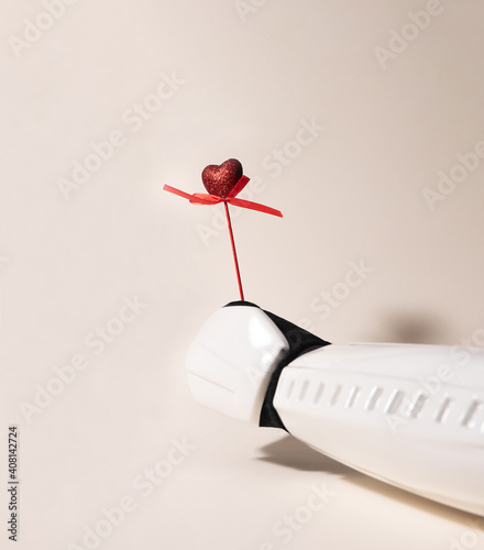 Εκτύπωση καμβά From right bottom side Storm trooper hand is offering red glittery heart on pink wood stick on a beige background with a shadow