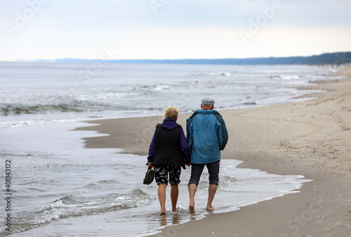 Fototapeta Naklejka Na Ścianę i Meble -  Active and healthy lifestyle. Walking on a sandy beach sea shore
