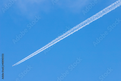condensation trail of a plane in the blue sky
