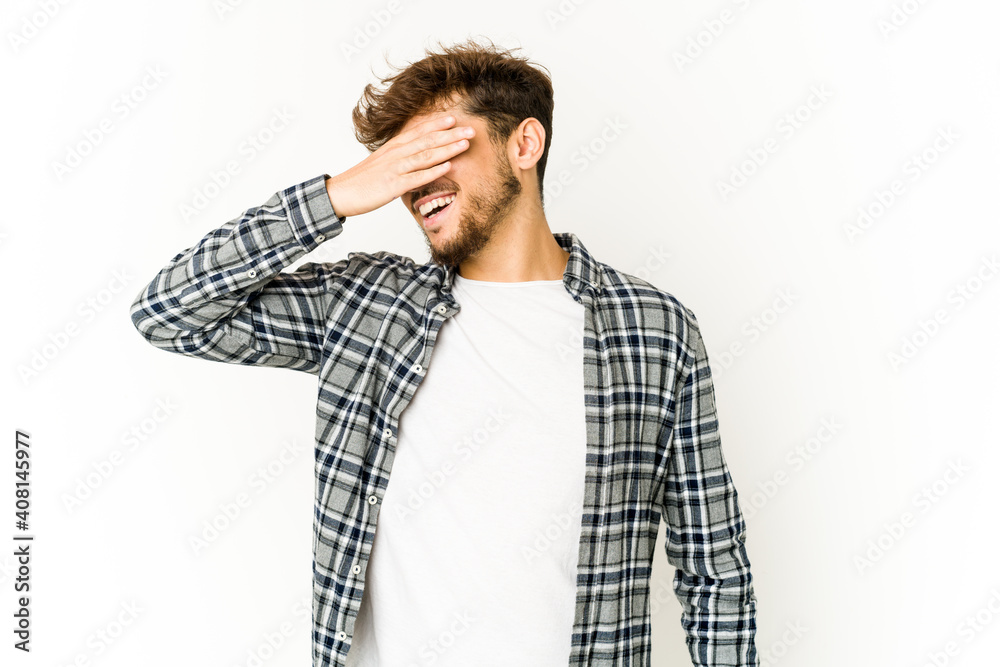 Young arab man on white background covers eyes with hands, smiles broadly waiting for a surprise. Young arab man on white background covers eyes with hands, smiles broadly waiting for a surprise.