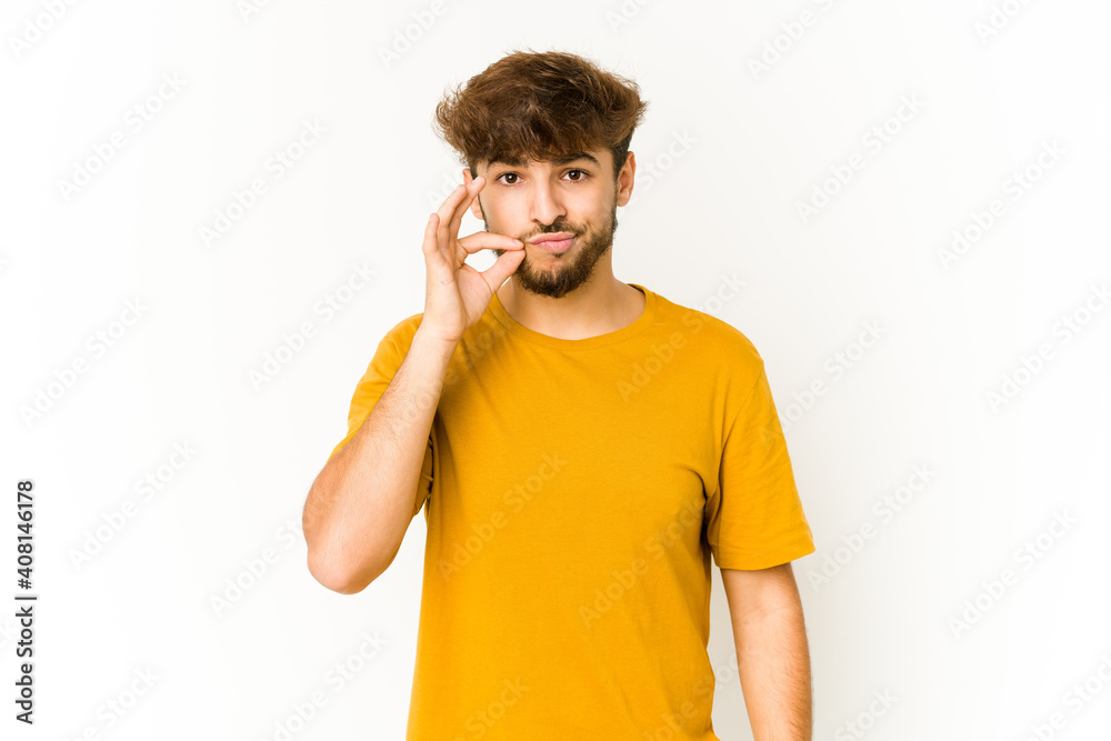 Young arab man on white background with fingers on lips keeping a secret. Young arab man on white background with fingers on lips keeping a secret.