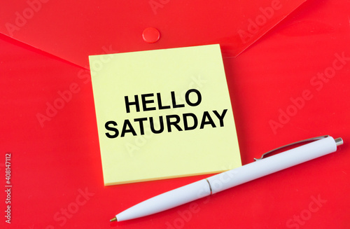 Yellow sticker with text Hello Saturday on red folder