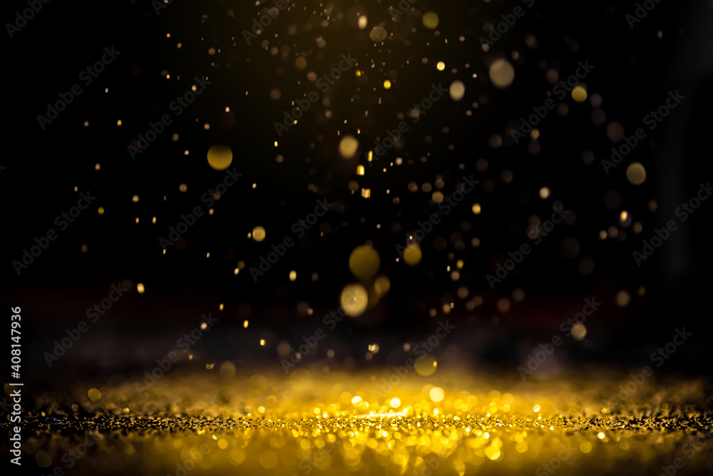 Gold abstract background. Glitter lights on black background. Defocused.