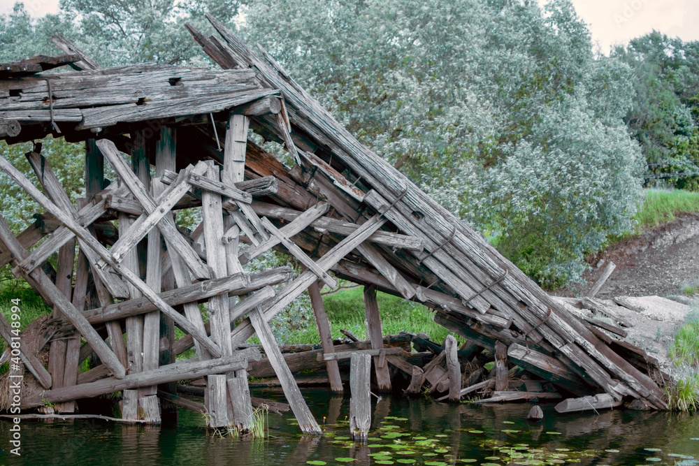 Logs of pillars of an old wooden bridge. Destroyed wooden old bridge