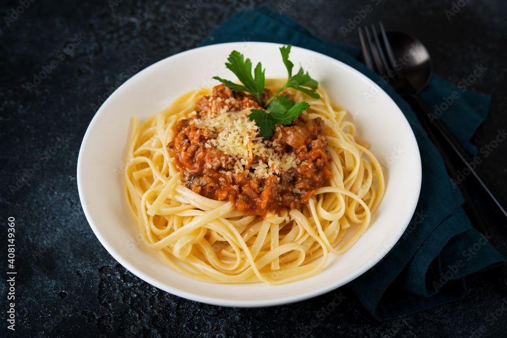 Italian pasta bolognese with greens on a black background Italian pasta bolognese with greens on a black background