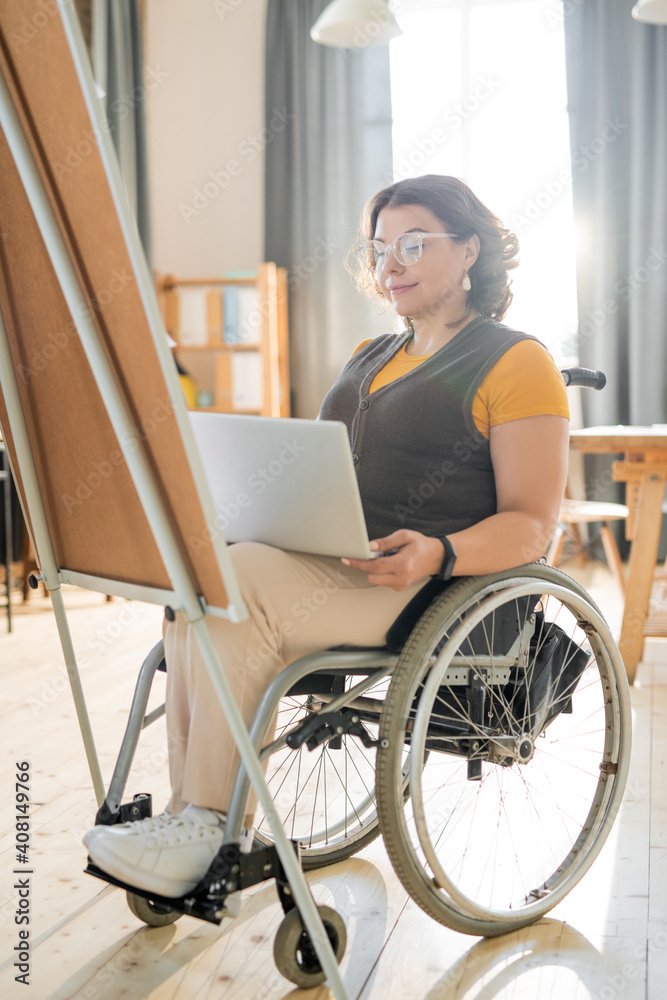 Disable businesswoman looking at laptop display while preparing presentation Disable businesswoman looking at laptop display while preparing presentation