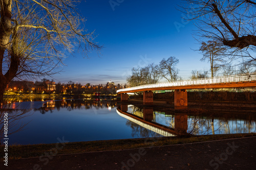 Obraz na płótnie Illuminated bridge over a river in a city park at night w salonie