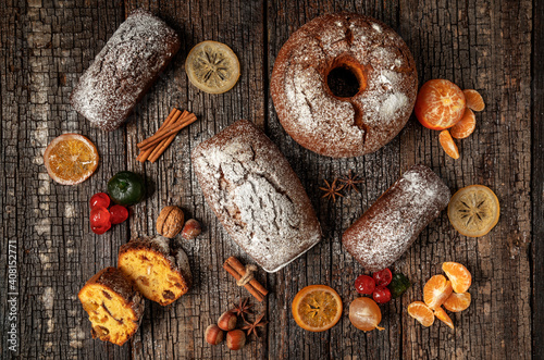 Christmas composition of dried fruits and stollen, with tangerine, on a wooden textured table, with spices. At Christmas.