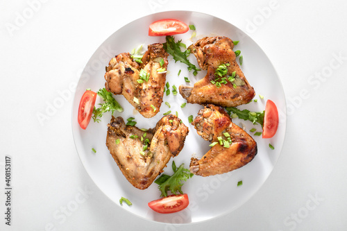 plate of baked chicken wings on a white background.