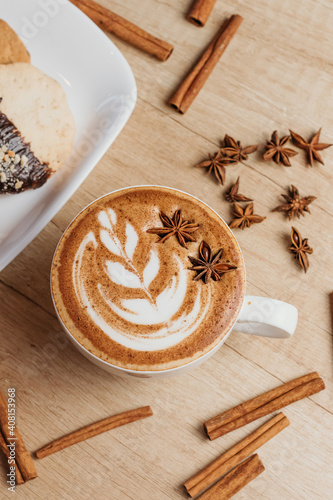 Spicy cappuccino with star anise and cinnamon in cafe.