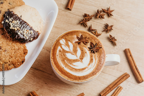 Spicy cappuccino with star anise and cinnamon in cafe.
