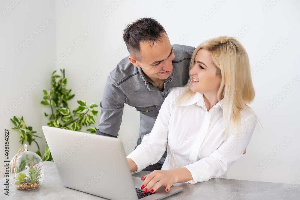 Couple working on laptop in office, woman and man with laptop Couple working on laptop in office, woman and man with laptop