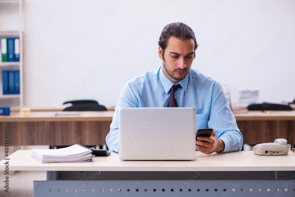 Young male employee working in the office Young male employee working in the office