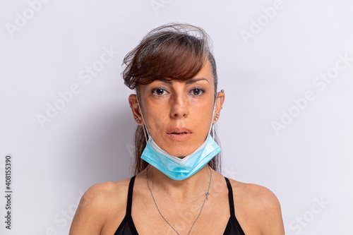 mulher mostrando o usa de incorreto da máscara protetora contra covid-19, ela está usando a mascar no queixo photo