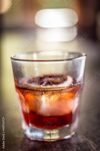 Old fashioned glass negroni cocktail alcohol drink beverage with orange slice and bokeh background
