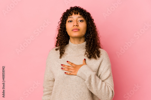 Quadro su tela Young african american afro woman isolated taking an oath, putting hand on chest