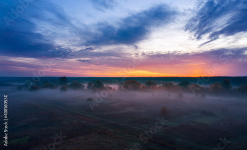 Morning landscape at sunrise with fog in a countryside field.