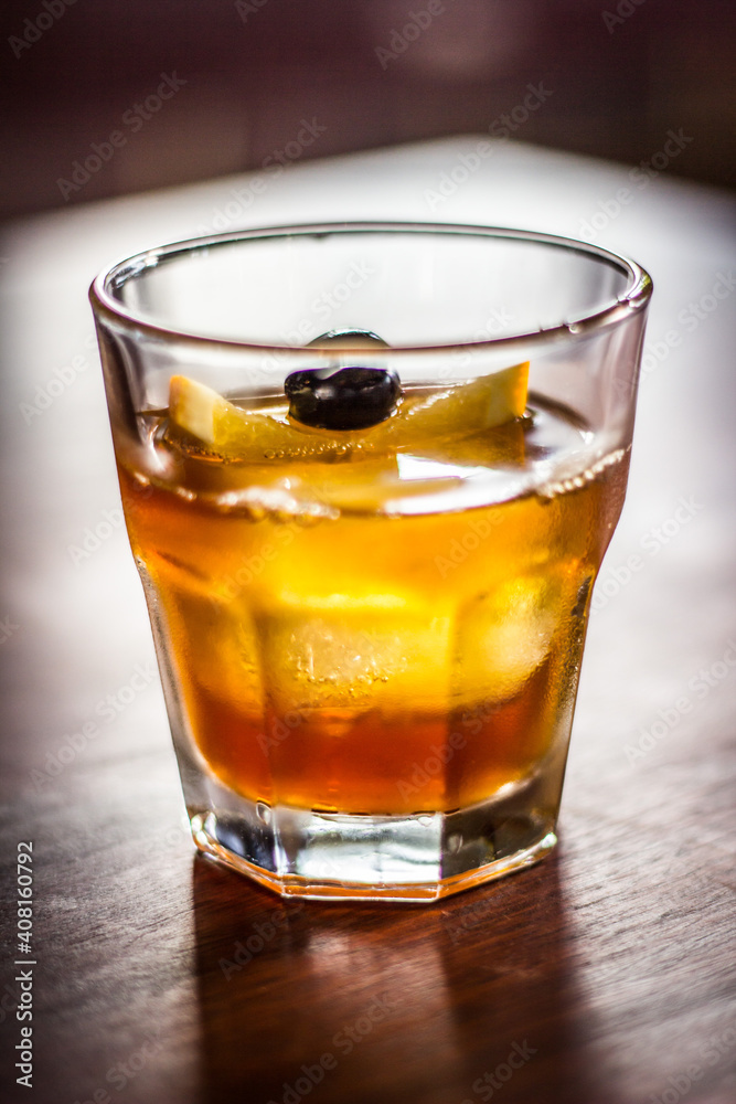 Dark n stormy cocktail alcohol drink beverage with lemon slices black olive ice and bokeh background Dark n stormy cocktail alcohol drink beverage with lemon slices black olive ice and bokeh background