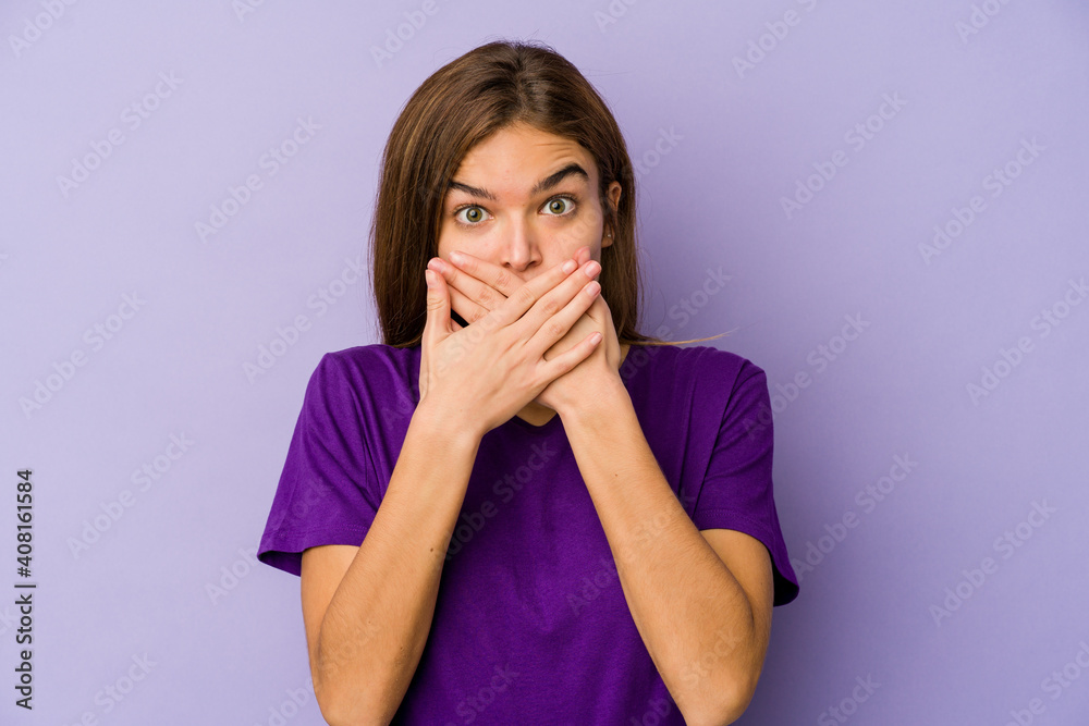Young skinny caucasian girl teenager on purple background shocked covering mouth with hands. Young skinny caucasian girl teenager on purple background shocked covering mouth with hands.